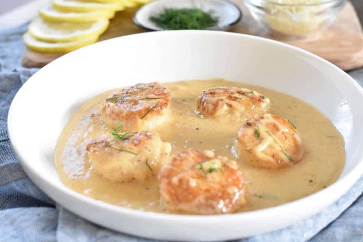 Garlic scallops in a white bowl.