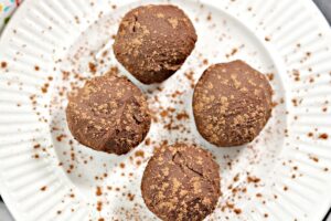 4 Chocolate Keto Truffles on a white plate.