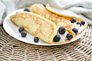 Keto Crepes on a plate with blueberries.