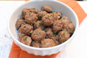 A bowl of freshly cooked Carnivore Meatballs garnished with herbs, ready to be served.