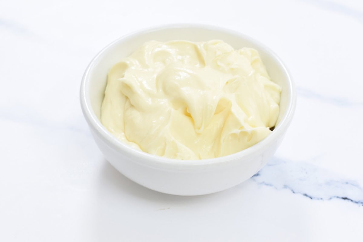 Cream cheese frosting in a white bowl.