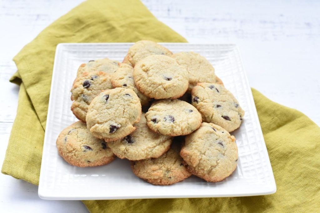 Chocolate chip cookies on a white plate.