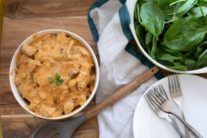 Instant Pot Chicken Paprika in a white bowl with salad.
