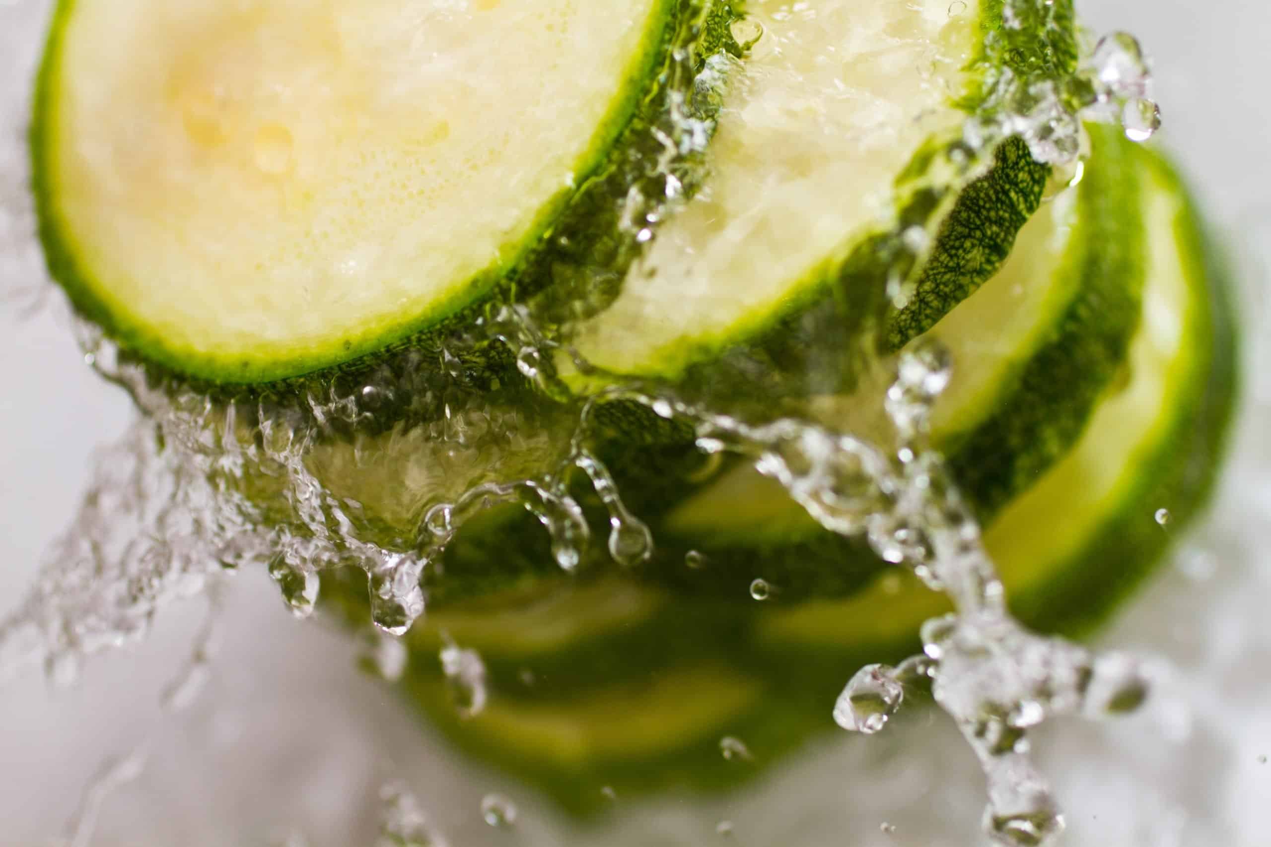 Refreshing and vibrant zucchini slices submerged in water, capturing the pure and invigorating essence of healthy eating and fresh produce.