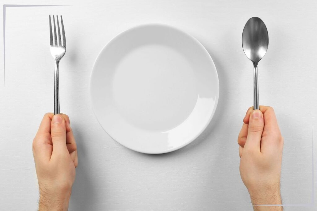An empty plate with a fork and spoon.