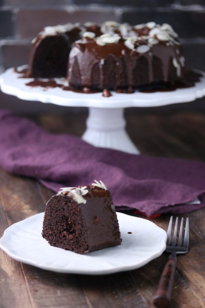 A slice of keto chocolate bundt cake on a white plate.