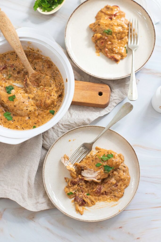 A bowl of Marry Me Chicken on white plates.