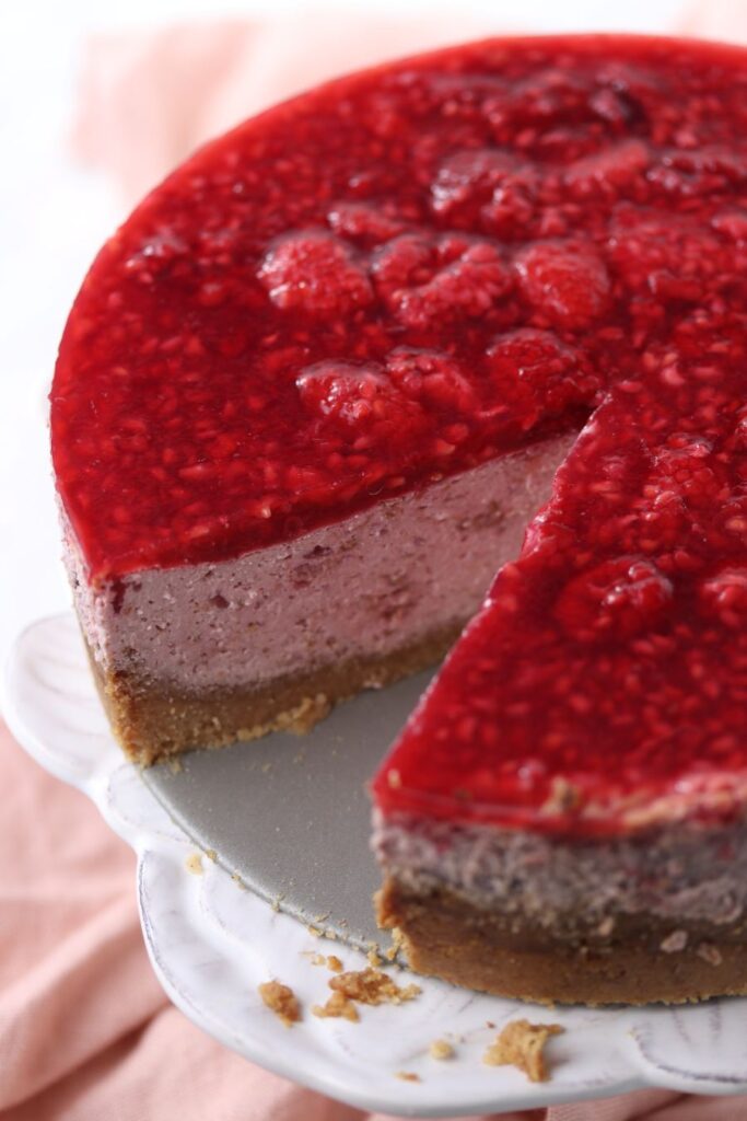 Keto raspberry cheesecake with a slice taken out.