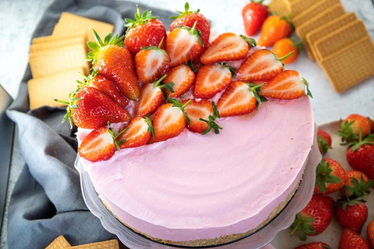 A beautiful keto strawberry cheesecake with strawberries on top.