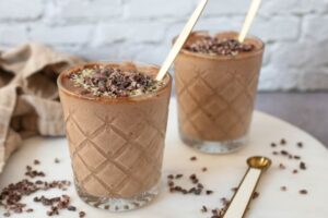 A peanut butter pudding in a glass with a spoon.