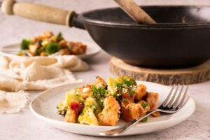 Honey Garlic Chicken with Broccoli on a plate with a pan in the background.