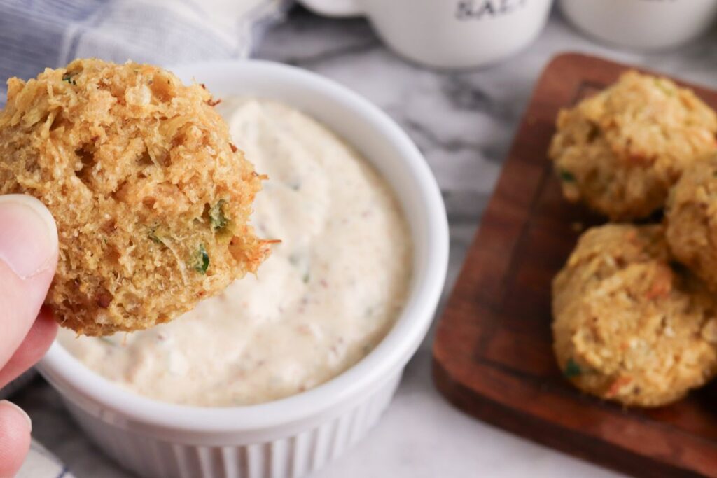 Mini Keto Crab Cakes being dipped in a sauce.
