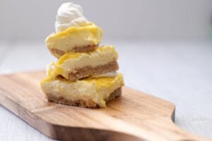 3 Keto Key Lime Bars stacked on a board.