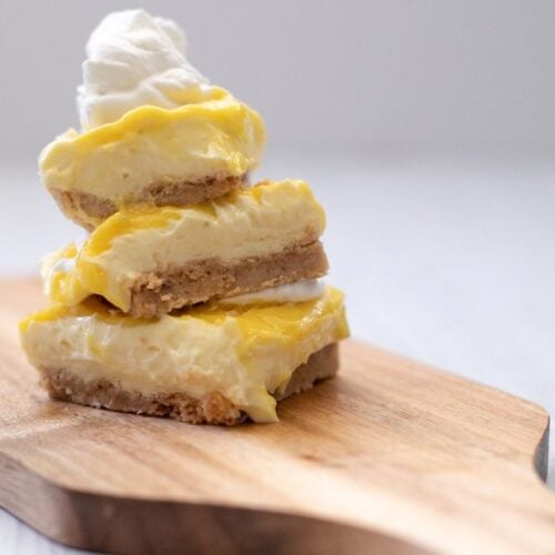 3 Keto Key Lime Bars stacked on a board.